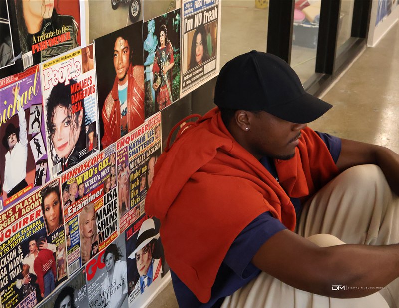 Seated portrait beside a music magazine wall