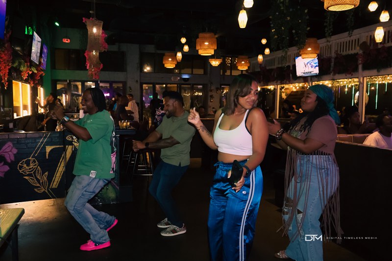 Guests dancing beneath warm pendant lights